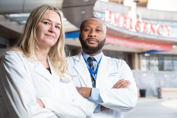 Dr. Krista Haines and Dr. Anthony Eze stand outside of the Duke Emergency Department.