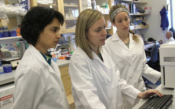 Dr. Smita Nair and colleagues collaborate in the lab. Photo by Shawn Rocco, 2018.