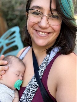 Dr. Gabby Dailey holds her baby and smiles at the camera