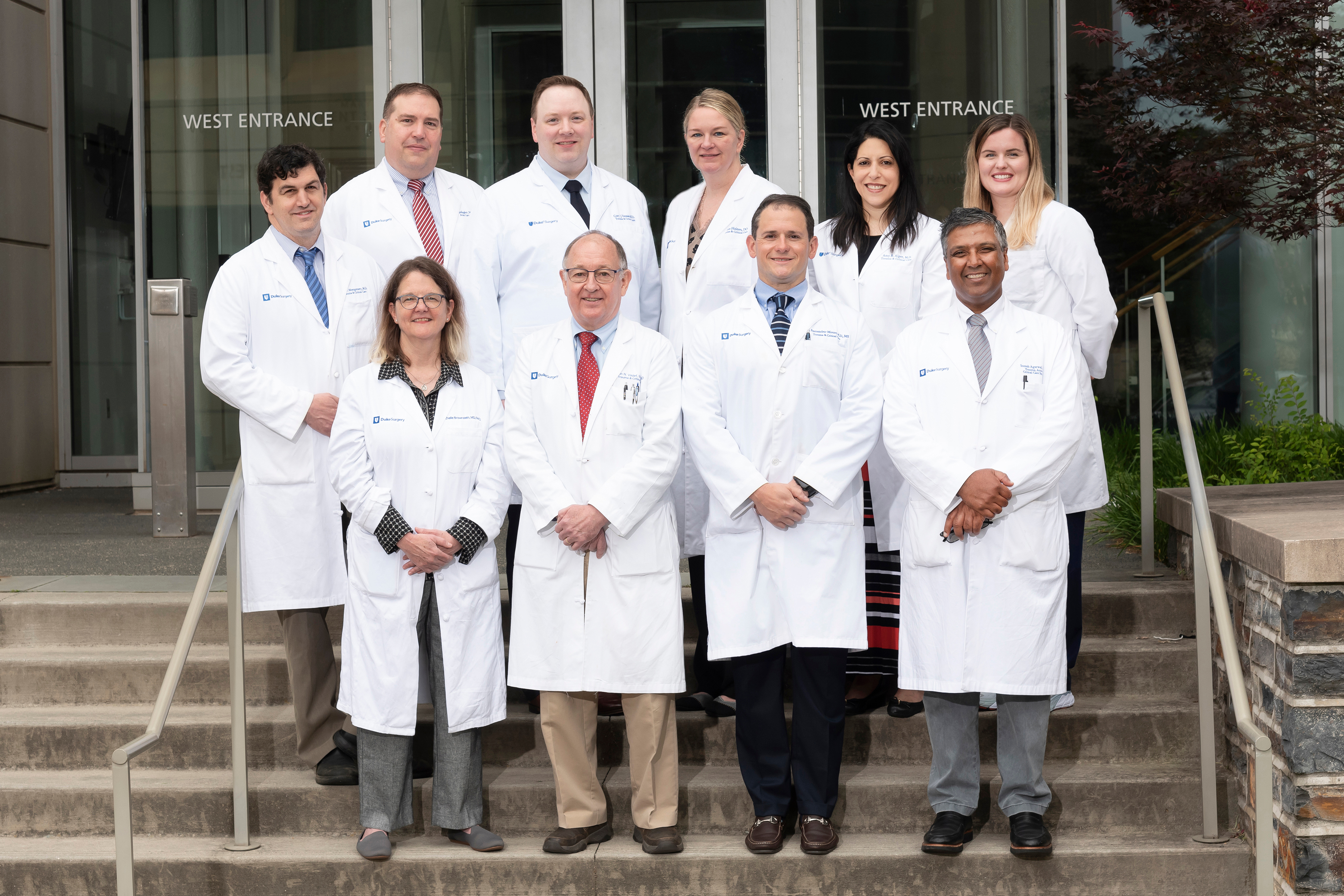 Group photo of Trauma division faculty in their white coats outside of the hospital