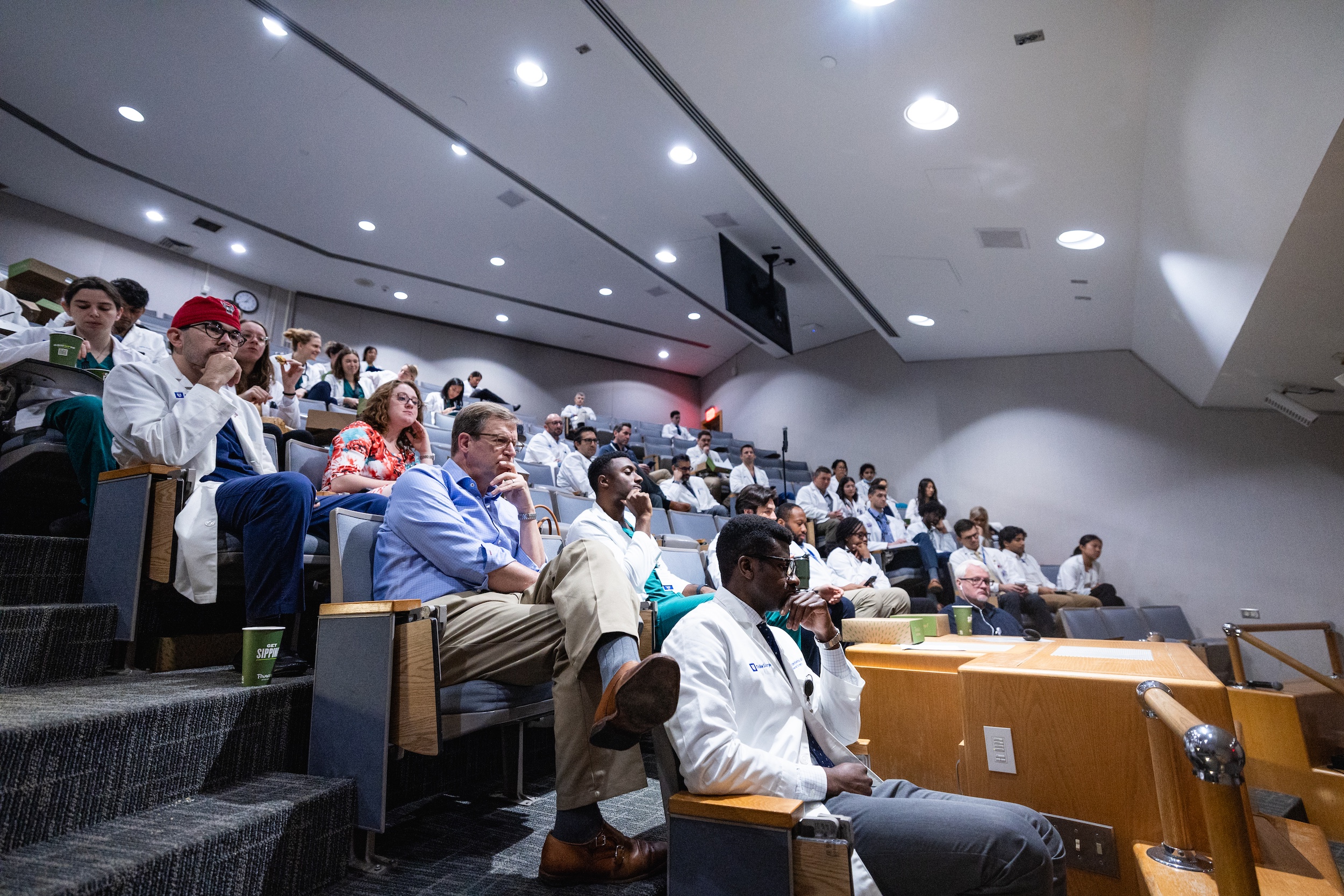 A group of physicians sit in a lecture hall