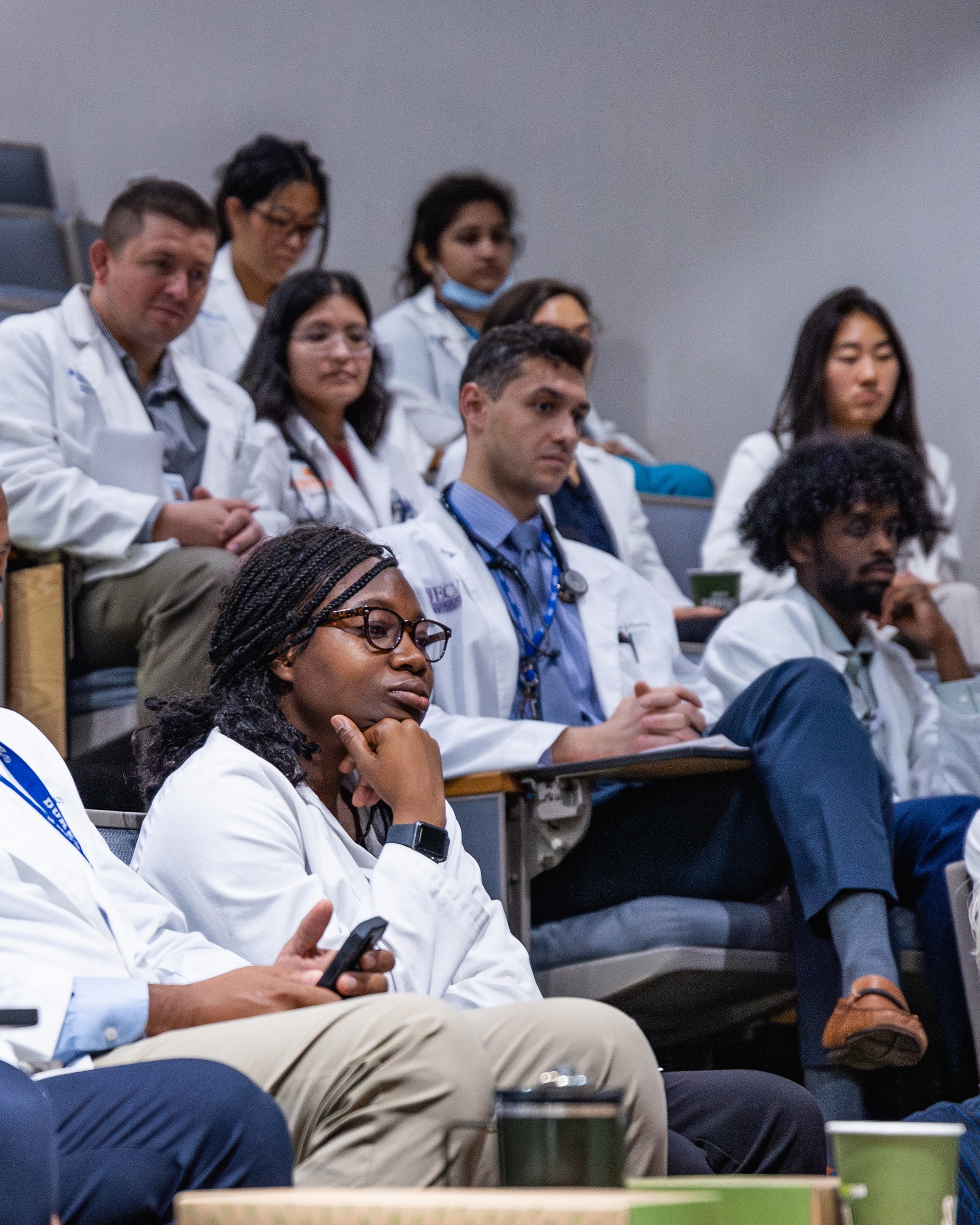 A group of physicians sit in a lecture hall