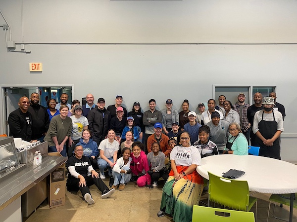 A group of people pose for a photo in a service kitchen