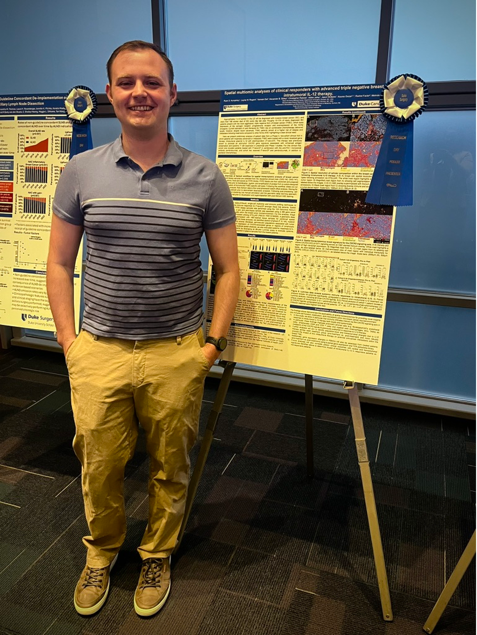A man stands in front of a scientific research poster 