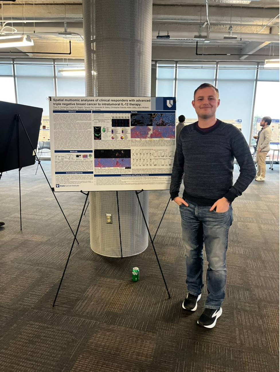 A man stands in front of a scientific research poster 