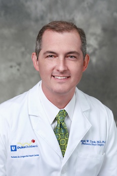 Headshot photo of Dr. Joseph Turek, wearing his white coat and seated against a grey background
