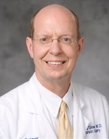 Professional headshot photo of Dr. Donald Glower wearing his white coat