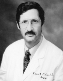 Black and white photo of Dr. Richard McCann wearing his white physicians coat