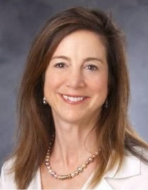 Professional headshot photo of Dr. Cynthia K. Shortell wearing a white blouse and gold necklace