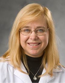 Professional headshot photo of Dr. Debra Sudan wearing her white coat
