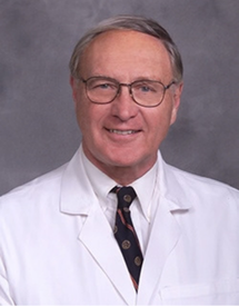 Professional headshot photo of Dr. Walter G. Wolfe wearing his white physicians coat