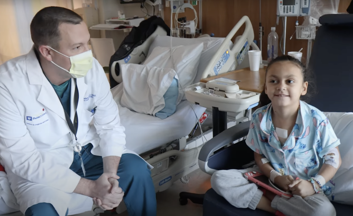 Dr. Doug Overbey sits in a hospital room with his patient, Kensley