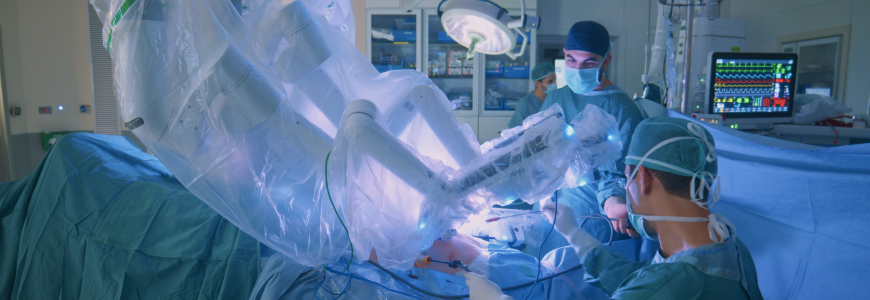 Surgeons in an operating room use a robotic device for a procedure