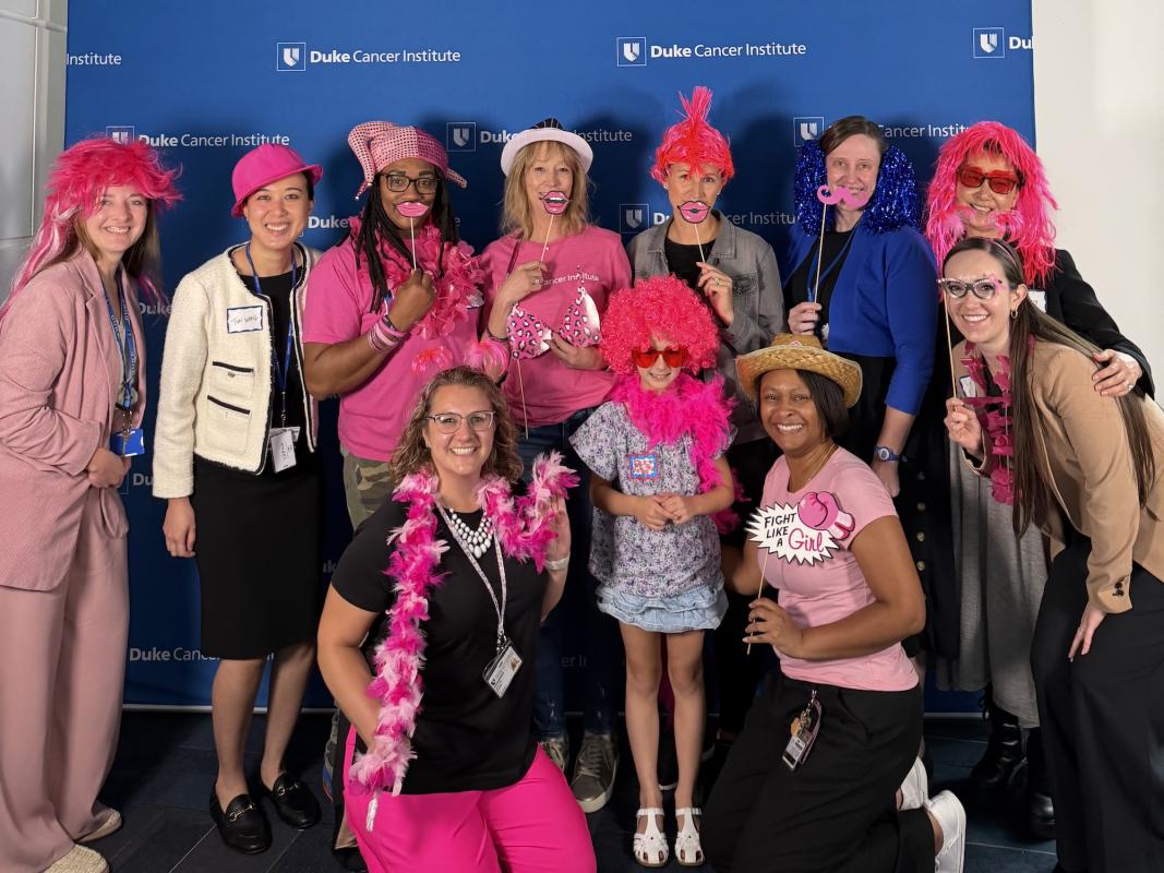 A group of 11 women gather for a photo while wearing fun pink accessories to celebrate the What's Best for Breasts annual community event