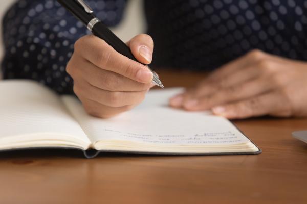 Close up of a women writing in a notebook