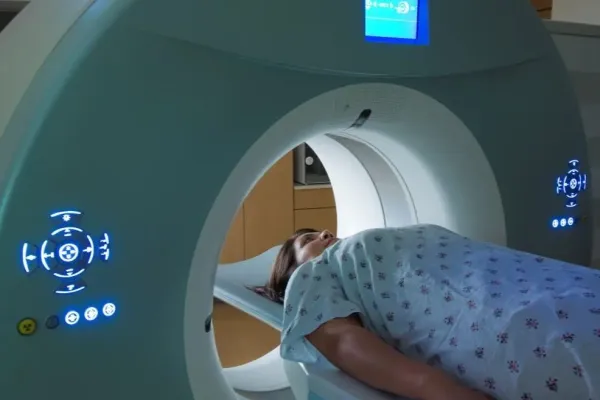 a woman lays on a table getting an MRI scan