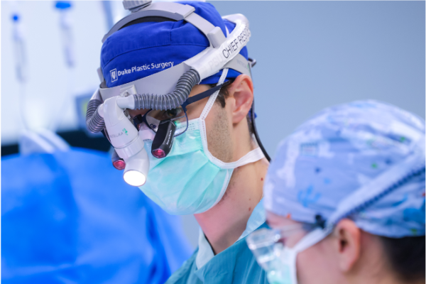 A male surgeon in scrubs and surgical gear 