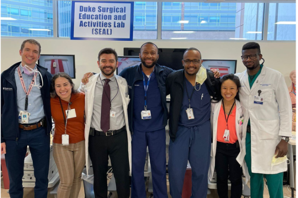 A group of residents post together in front of a sign reading Duke Surgical Education and Activities Lab (SEAL)