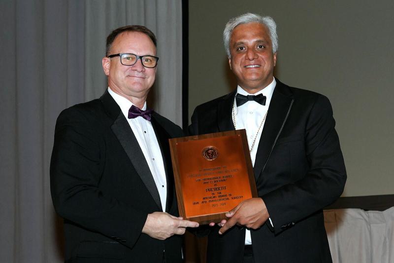 Dr. David Powers stands with a colleague who presents him with an award