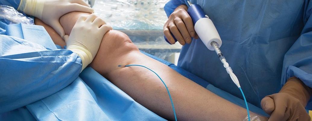 A physician holds an instrument over a patient's arm