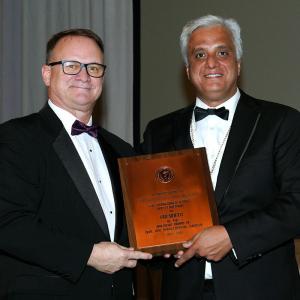 Dr. David Powers stands with a colleague who presents him with an award