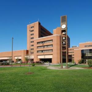 front of the Durham VA health care system building, in front of a blue sky and green lawn