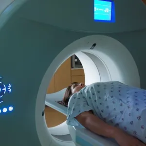 a woman lays on a table getting an MRI scan